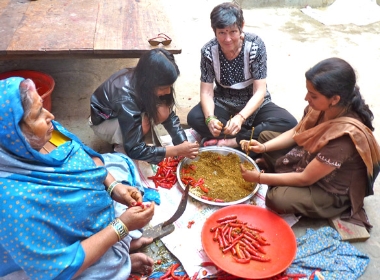 Susan Wallace and village women stuffing spices into red chilies (February 2010)